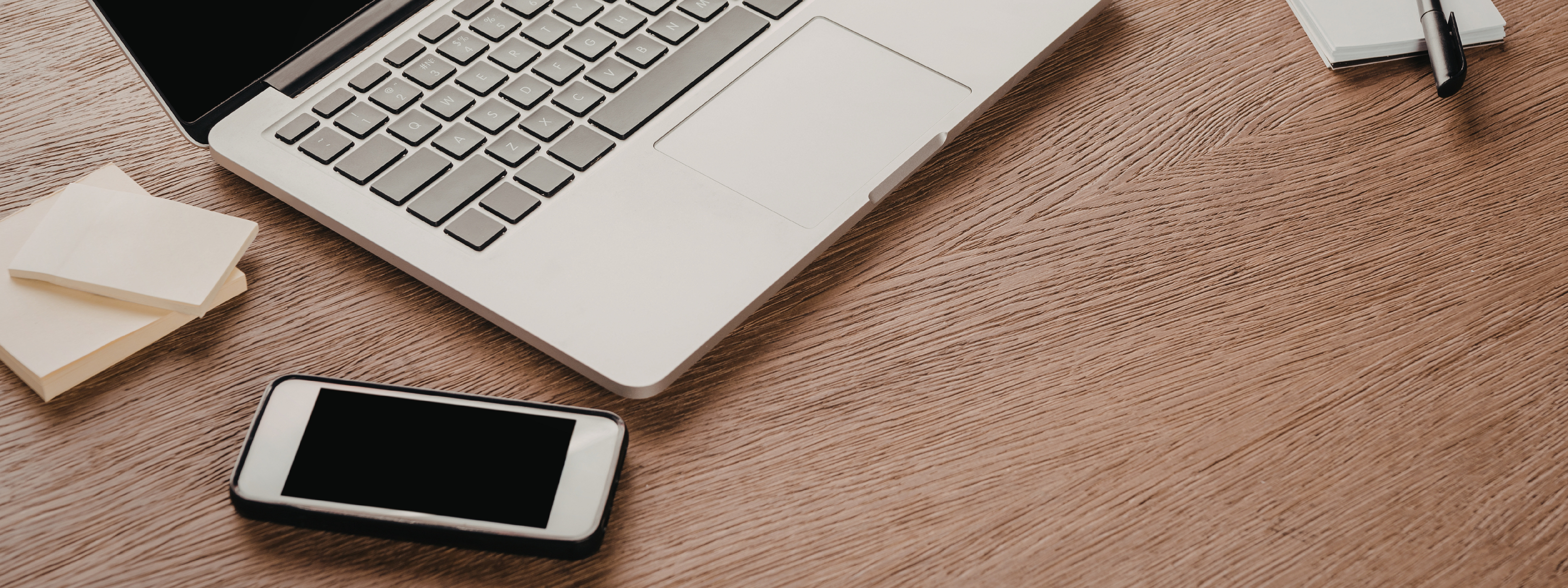 Laptop and smartphone on a wooden desk