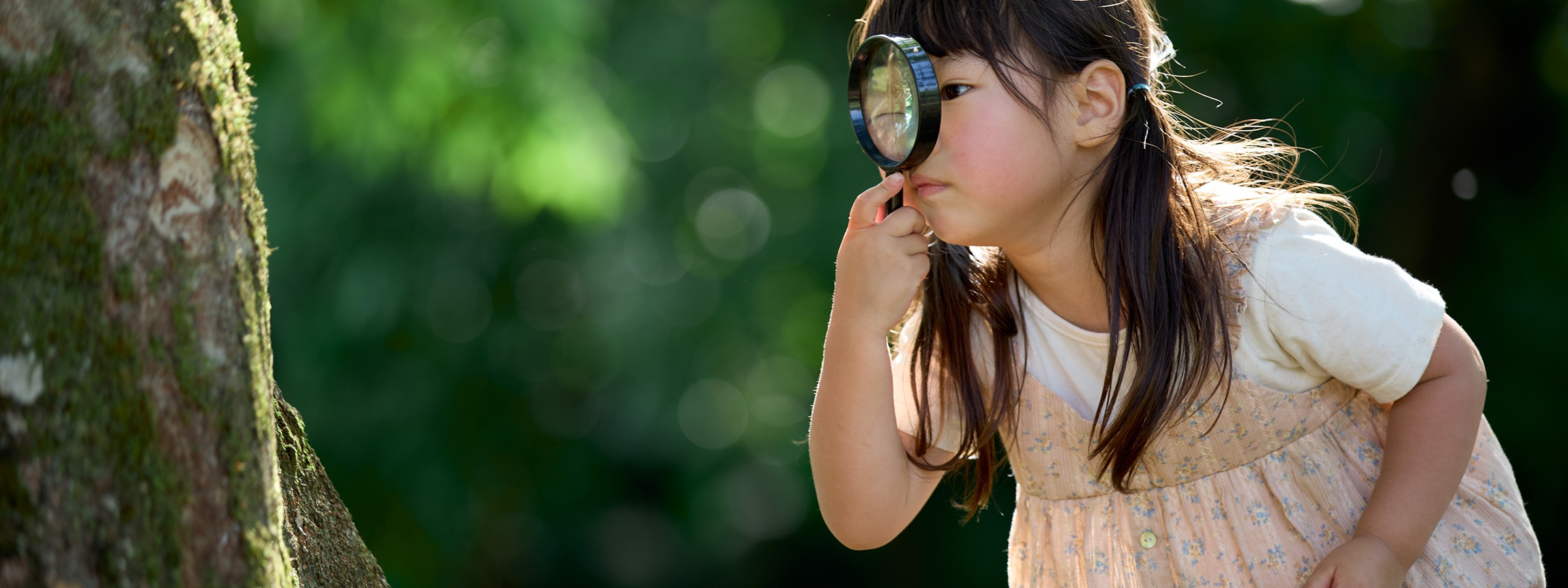 Child with a magnifying glass exploring nature