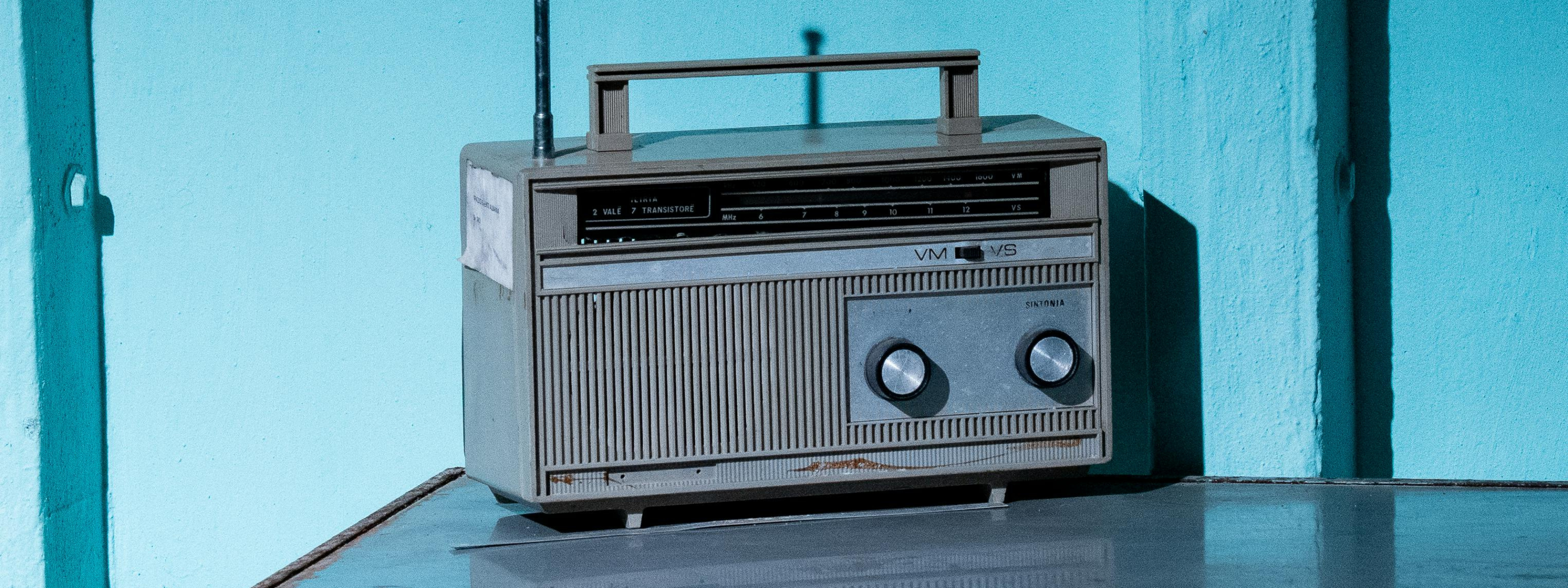 Vintage-style radio receiver on a reflective surface with a blue gradient background
